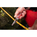 Using a Leatherman Skeletool RX Multitool, a first responder with the red-handled emergency tool attached to a lanyard cuts a yellow rope with red markings near water.