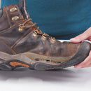 Brown leather boot with visible wear on a white surface