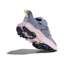 The Hoka Womens Anacapa 2 Low GORE-TEX Hiking Shoe is shown on a white background, featuring light purple and pink uppers with a rugged black and pink sole, angled to highlight its tread and side details.