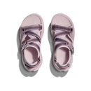 The Hoka Womens Infini Hike TC Trail Sandal, shown from above on a white background, features light purple color and adjustable straps inspired by the comfort of Hoka running shoes. Soft shadows extend to the left.