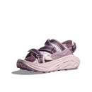 The Hoka Womens Infini Hike TC Trail Sandal, shown at an angle on a white background, features purple and pink hues, a thick textured sole, and adjustable Velcro straps inspired by Hoka Running Shoes comfort.