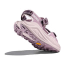 The Womens Infini Hike TC Trail Sandal by Hoka is displayed from a low angle, showcasing its thick, rugged sole inspired by Hoka Running Shoes, plus adjustable straps, on a white background.