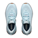 A pair of Hoka Women’s Transport 2 sneakers in light blue are shown from above, showcasing white toggle laces, orange accents on the toe and heel, and dark insoles with the Hoka logo in white. These sustainable city-to-trail shoes blend style and performance for everyday adventures.