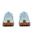 Pair of light blue Hoka Womens Transport 2 athletic shoes viewed from the back, featuring brown outsoles and black and yellow logo details on the heel area—perfect as city-to-trail sneakers for those seeking both style and versatility.