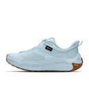 Introducing the Hoka Womens Transport 2: a light blue athletic shoe featuring a white midsole, brown Vibram sole, and a Cordura tag on the side. This sleek, modern design draws inspiration from city-to-trail sneakers, complete with visible stitching and a convenient heel pull tab—making it an ideal and versatile choice for those seeking sustainable running shoes.