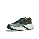 The Hoka Mens Speedgoat 7 Trail Running Shoe features a black, gray, and white design with orange accents on the side and heel, a thick textured sole, and a mesh upper, shown against a plain white background.