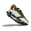 A rear side view of the Hoka Mens Speedgoat 7 Trail Running Shoe in gray and black with orange accents, featuring a thick textured sole and bold Hoka branding, set against a white background with a shadow.