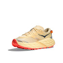 The Womens Speedgoat 7 Trail Running Shoe by Hoka features a beige and yellow design with orange accents, a thick textured sole, and a black side logo, shown angled on a white background.