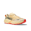 The Hoka Womens Speedgoat 7 Trail Running Shoe features a beige and tan upper, chunky sole, large black Hoka logo, orange heel tab, and bright orange outsole tread.