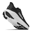 A black Hoka Mens Clifton 11 Running Shoe featuring white Hoka branding and a thick, white sole is shown from a low rear perspective, highlighting the tread and heel—an excellent showcase of these cushioned running shoes that are engineered to be the perfect daily trainer.