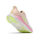 A Womens Clifton 11 Running Shoe by Hoka is shown angled on a white background, featuring a thick white sole with yellow-green accents, a soft light peach upper, and pink detailing. This pastel-colored design includes the signature Hoka logo on the side and delivers maximum comfort and cushioned support—the ideal daily trainer for style and ease.