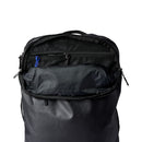 Cotopaxi’s Allpa 35L Travel Pack in black, shown with its main compartment unzipped, reveals an interior zippered mesh pocket and a blue zipper pull—all thoughtfully made from recycled fabrics for environmentally conscious travelers.