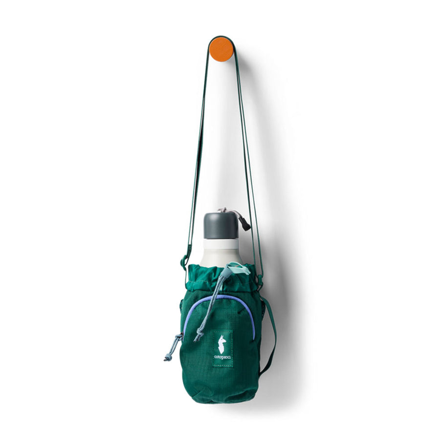 Green Cotopaxi water bottle holder with a water bottle on a white background