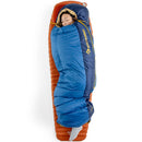 A person sleeps cozily with their eyes closed in a Sea to Summit Circuit Down Sleeping Bag (-1°C), blue and navy in color, resting their head on the hood, atop an orange sleeping pad.