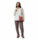 A woman faces forward in a Columbia Womens Benton Springs™ Half Snap Pullover, taupe pants, gray hiking boots with pink laces, and a red crossbody bag—an outfit that showcases versatile casual style against a white background.