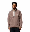 A man models the Columbia Mens Helvetia Half Snap Fleece, featuring a high collar and chest pocket, standing facing forward with a neutral expression against a plain white background.
