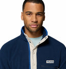 A man with short hair wears the Columbia Mens Helvetia Half Snap Fleece in blue and beige over a light blue shirt, looking directly at the camera against a white background.