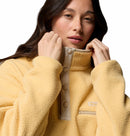 A person wears the Columbia Womens Helvetia II Cropped Sherpa Half Snap Fleece in light yellow, with a raised collar, sherpa-like texture, snap buttons, small chest pocket, and white background.