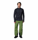 A man faces forward against a white background, wearing Columbias Mens Crystal Leaf Omni-Heat Helix Technical Half Zip Fleece in black, olive green outdoor pants, and black shoes.