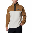 A man stands with one hand in his pocket against a plain background, wearing the Columbia Mens Steens Mountain™ II Half Snap Fleece featuring a black buttoned collar—an ideal choice for everyday comfort and style.