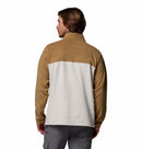 A man with brown hair and gray cargo pants wears the Columbia Mens Steens Mountain™ II Half Snap Fleece, featuring a tan upper and light gray lower section. The PFAS-free fleece is ideal for daily wear, shown against a white background.