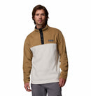 A man wearing the Columbia Mens Steens Mountain™ II Half Snap Fleece in tan and white with black buttons and gray pants stands facing forward against a white background, highlighting this PFAS-free fleece for everyday wear.