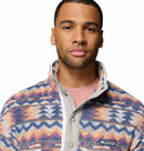 A man wearing the Columbia Mens Helvetia II Printed Half Snap Fleece with a high collar and a light pink shirt underneath stands against a white background.