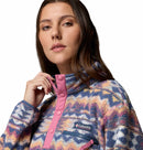 A woman wears the Columbia Womens Helvetia II Cropped Sherpa Half Snap Printed Fleece with pink accents, confidently gazing at the camera against a white background.