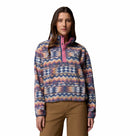 A woman faces forward against a white background, wearing tan pants and the Columbia Womens Helvetia II Cropped Sherpa Half Snap Printed Fleece, featuring a colorful print and pink snap-button collar.