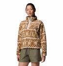 A woman models the Columbia Womens Helvetia II Cropped Sherpa Half Snap Printed Fleece in tan and white, paired with olive green shorts against a plain white background.