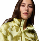 A woman with long brown hair wears the Columbia Womens Helvetia II Cropped Sherpa Half Snap Printed Fleece, collar partially buttoned, confidently facing the camera against a white background.