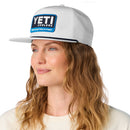 Woman wearing a white cap with YETI Coolers logo on a white background