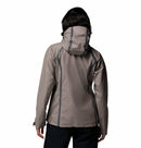 A woman with shoulder-length dark hair wears a light gray Columbia Womens Reign No Shine Waterproof Jacket with dark seams, standing with her back to the camera against a white background.