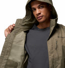 A man wears an olive green Columbia Mens Pouring Adventure™ III Waterproof Hiking Jacket over a dark gray t-shirt, holding it open to reveal the mesh lining inside.