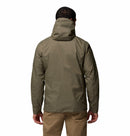 A person is shown from the back wearing a light brown Columbia Mens Pouring Adventure™ III Waterproof Hiking Jacket and tan pants, standing against a plain white background.