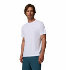 A man with light brown hair and a short beard is wearing the Columbia Mens Zero Rules™ Light Technical T-Shirt in white and teal pants, standing against a white background.