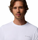 A man with wavy brown hair and light facial hair wears a plain white Columbia Mens Zero Rules™ Light Technical T-Shirt with cooling technology, looking at the camera against a white background.