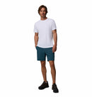 A man with short brown hair stands against a white background wearing a Columbia Mens Zero Rules™ Light Technical T-Shirt, teal shorts, and black athletic shoes. He looks forward with a slight smile.