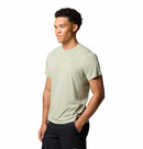 A man stands against a white background wearing the Columbia Mens Zero Rules™ Light Technical T-Shirt in light beige and black shorts, looking slightly to the side with a neutral expression.