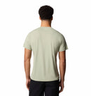A man with short curly hair is seen from the back, wearing the Columbia Mens Zero Rules™ Light Technical T-Shirt in beige and black shorts, standing against a plain white background.