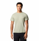 A young man stands facing forward against a plain white background, wearing a Columbia Mens Zero Rules™ Light Technical T-Shirt in light green and black pants.