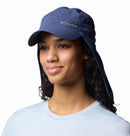 A woman wearing a Columbia Schooner Bank II Cachalot Hat (UPF 50, neck flap) and a light blue shirt smiles against a white background.