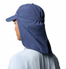 A person wearing a Columbia Schooner Bank II Cachalot Hat in blue, featuring UPF 50 sun protection and a long neck flap, is seen from behind, paired with a light blue shirt. The hat offers enhanced coverage for the neck and head.