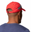 A man, seen from behind, wears a Columbia Tech Shade II Cap with mesh panels and an adjustable strap. He also has on a blue shirt against a plain white background.