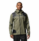 A man wears the Columbia Mens Whistler Peak Waterproof Shell Jacket in light olive green and black, featuring a hood, front zipper, and zippered pockets—ideal for hiking—standing against a plain white background.