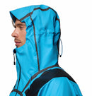 A man is shown in profile wearing the Columbia Mens Whistler Peak Waterproof Shell Jacket in bright blue with a hood and black accents, set against a plain white background.