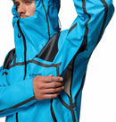 A man wearing the Columbia Mens Whistler Peak Waterproof Shell Jacket unzips an underarm vent, showcasing the hiking jacket’s thoughtful design and breathable features.