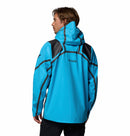 A man in a bright blue Columbia Mens Whistler Peak Waterproof Shell Jacket with black accents stands facing away, looking to the side against a plain white background.