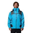 A man wearing a Columbia Mens Whistler Peak Waterproof Shell Jacket in bright blue with black accents stands against a plain white background, facing forward with his hands relaxed by his sides.