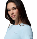 A young woman with long brown hair wears the Columbia Womens Zero Rules Light Technical T-shirt, standing against a white background and looking confidently at the camera—ready for hiking in sweat-activated cooling comfort.